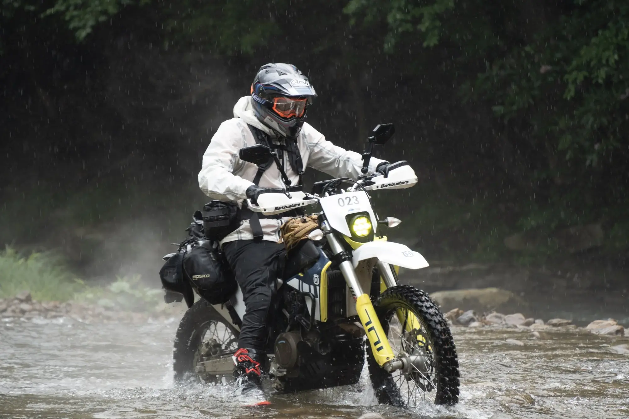 A rider on a dual sport motorcycle crossing a river during the Appalachian 1000